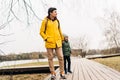 Father in yellow raincoat and son having fun in forest. Happy family with child kid boy playing and having fun outdoors Royalty Free Stock Photo