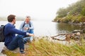 Father and young adult son talking by a lake Royalty Free Stock Photo