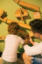 Father and young son are busy building structure made of large parts in children`s research and development center. Learning