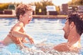 Father With Young Son Having Fun On Summer Vacation Splashing In Outdoor Swimming Pool Royalty Free Stock Photo