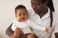 Fatherhood Concept. Caring Father Holding Little Crying Black Baby On Hands Royalty Free Stock Photo