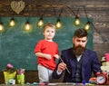 Fatherhood concept. Talented artist spend time with son. Teacher with beard, father teaches little son to draw in
