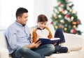 Happy father and son reading book at christmas Royalty Free Stock Photo