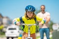 Fathers day. Boy learning to ride a bicycle with his father in park on summer day. Father teaching his son cycling on Royalty Free Stock Photo