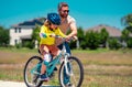 Fathers day. Boy learning to ride a bicycle with his father in park on summer day. Father teaching his son cycling on Royalty Free Stock Photo