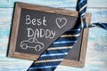 Fathers day concept, Best Daddy and car written on chalkboard with blue striped tie on wooden background