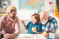 Fathers day. Family relationship between grandfather father and son. Grandpa teaching school boy learning to write and