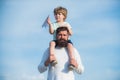 Fathers day. Father giving son ride on back in park. Happy family and little son playing on blue summer sky. Garden Royalty Free Stock Photo