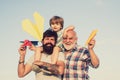 Fathers day - grandfather, father and son are hugging and having fun together. Kid pilot with toy jetpack against sky