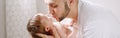 Fathers Day holiday. Happy Caucasian father kissing newborn baby. Dad man parent holding child daughter son in hands. Authentic Royalty Free Stock Photo