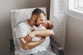 Fathers Day holiday. Proud Caucasian father kissing newborn baby girl. Parent holding rocking child daughter son on hands. Royalty Free Stock Photo