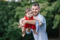 Fathers Day. Middle age Caucasian proud father dad hugging playing with toddler baby girl outdoors. Parent holding carrying