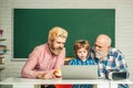 Fathers Day. Teacher parents helping child pupil studying in classroom. Parenting and kids concept.