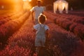 Fathers day. Young dad and toddler child daughter are having fun in a lavender field in full bloom on sunset light Royalty Free Stock Photo