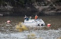 Fathers and sons out in river on pontoon boat fishing with rock cliffs behind and blurred out leaves and branches framing Ketchum