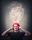 Fatigue and annoyed man, keeps fingers to his temples, feels like mind is boiling as dense steam comes out of his head. Brain Royalty Free Stock Photo