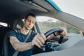 Fatigue of sleeping driver driving at speed while holding wheel while driving on highway in forest. Front view of exhausted man. Royalty Free Stock Photo