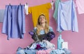 Fatigue woman looks away, stands near basket with pile of laundry