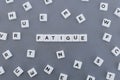 Fatigue word made of square letter word on grey background
