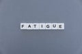 Fatigue word made of square letter word on grey background