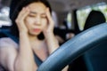 fatigued Asian woman having headache migraine while driving, discomfort, stress, and exhaustion in a car Royalty Free Stock Photo