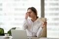 Fatigued businesswoman taking off glasses tired of computer work