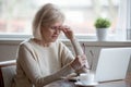 Fatigued mature woman taking off glasses suffering from eye stra Royalty Free Stock Photo