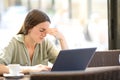 Fatigued woman suffering eyestrain in a coffee shop