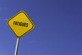 fatigues - yellow sign with blue sky background