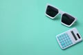 Fatlay Modern white sunglasses fashion and Green calculator on pastel green background.