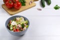 Fattoush salad in a gray bowl with ingredients on a white background. Copy space.