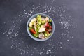 Fattoush vegetarian salad in a gray bowl against black background. Top view.
