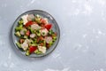 Fattoush vegetarian salad in a gray plate on a gray background. Copy space. Top view.