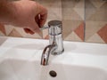 Faucet in the bathroom with running water. Man constantly turns off the water to conserve water energy and protect the environment Royalty Free Stock Photo