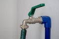 Faucet and green hose attached to the blue poly pipe Royalty Free Stock Photo