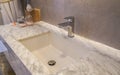 Faucet and luxury marble washbasin in hotel bathroom
