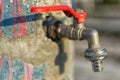 Faucet on Old Blue Painted Wall. Red Handle Water Tap Outdoor Background. Save Water Concept. Royalty Free Stock Photo