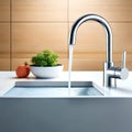 Faucet running water in sink indoors with few home appliance and indoor and outdoor backdrops