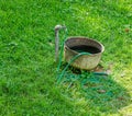 Faucet, tub and garden hose on lawn Royalty Free Stock Photo