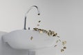 a faucet from which gold dollar coins fall into the washbasin. 3d render