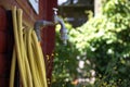 Faucet with yellow garden hose next to red garden shed Royalty Free Stock Photo