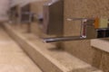 Faucets on the washbasin in the public toilet. Soft focus. Close-up