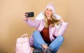 Faux fur fashion. warm winter clothing. phone selfie. flu and cold season. Leather bag fashion. woman in beanie hat with