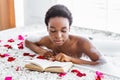 Favorite book and relaxing. Concentrated girl reads book, sitting in bathroom with foam Royalty Free Stock Photo