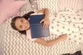 Favorite fairy tale. I wish it was true story. Girl child lay bed read book. Pleasant time in cozy bedroom. Girl kid Royalty Free Stock Photo