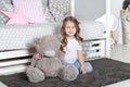 Favorite toy. Girl child sit on bed hug teddy bear in her bedroom. Kid prepare to go to bed. Pleasant time in cozy bedroom. Girl k Royalty Free Stock Photo