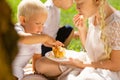 Little child eating a delicious cake in the park