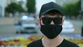 FBI agency male provocateur in coronavirus black face mask, glasses and cap.