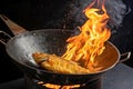 A fish is being fried in a large, round wok with a wooden handle. Royalty Free Stock Photo