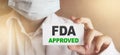 FDA Approved words on card Doctor shows. Food and Drugs Association approved products concept